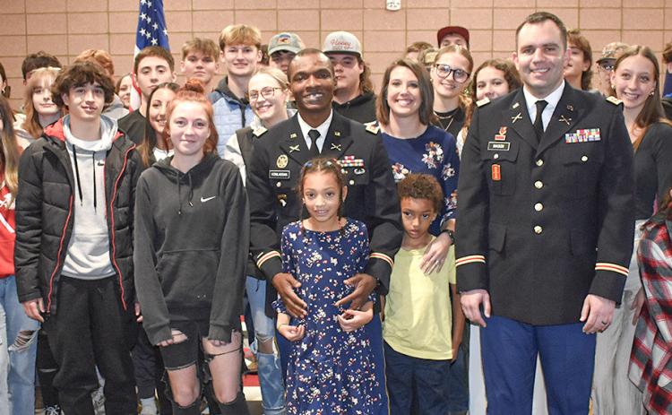 Beaverton High School teacher Kossi Komlassan poses with his family, his commanding officer and his students after the school hosted a ceremony when he was promoted to the rank of major in the Army National Guard.