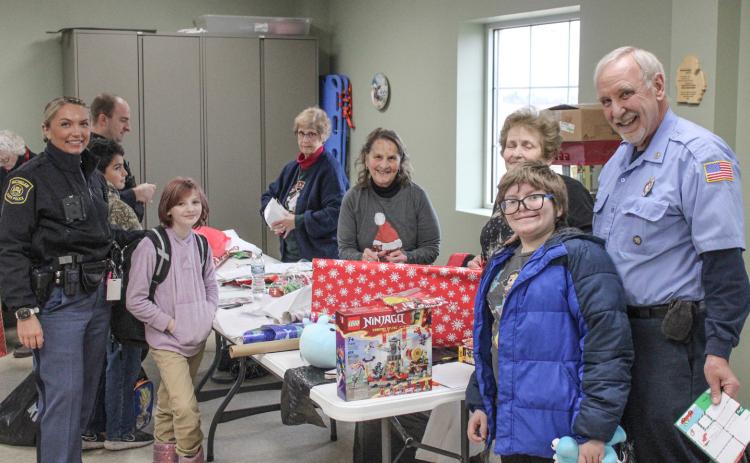After a big Christmas shopping trip, the next step is to wrap the presents and that’s what this bunch was up to Thursday at the Beaverton Fire Dept. during the annual Shop With A Hero festivities.