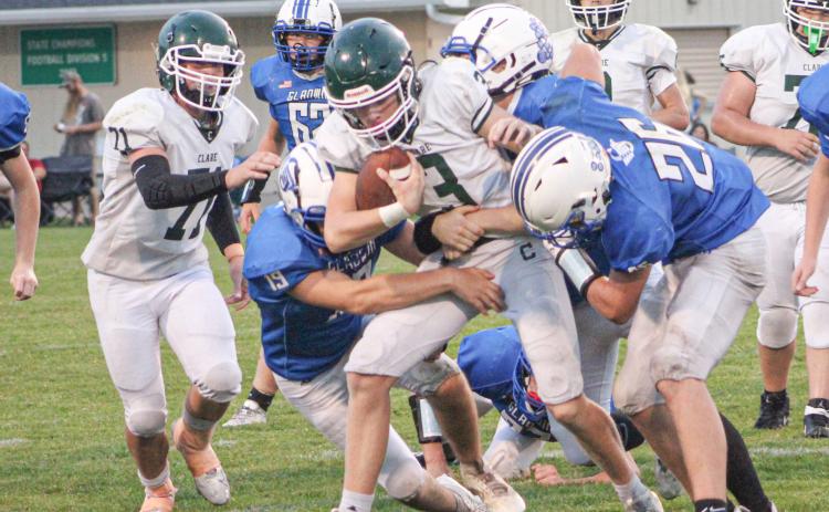 Gladwin’s Leo Orvis and Hunter Wooster wrap up Clare ball-carrier Dalton Kruskamp during Thursday night’s junior varsity contest.