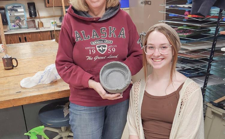 Art guild member Jan Berg-Rezmer and student leader Tori Johnson show off the first finished bowl for Empty Bowls 2025!