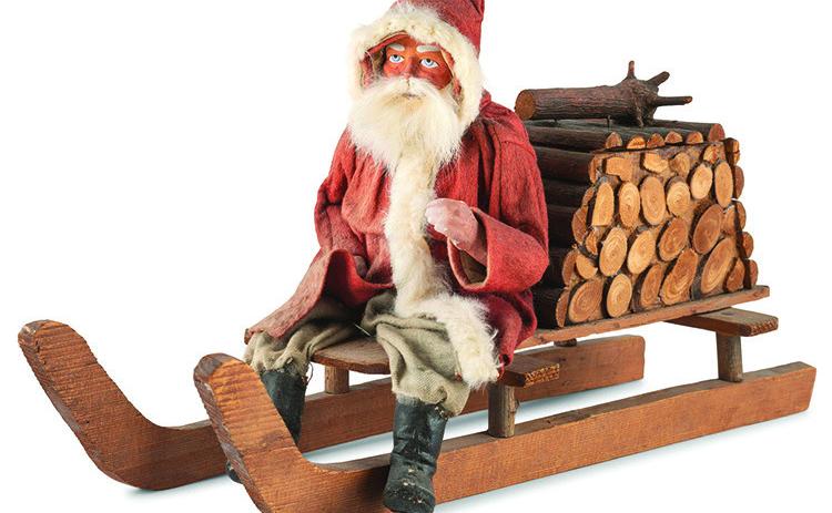 Leave it to Santa Claus to fill a bundle of firewood with candy! This papier-mache figure of Santa on a sled is a candy container. KOVELS.COM