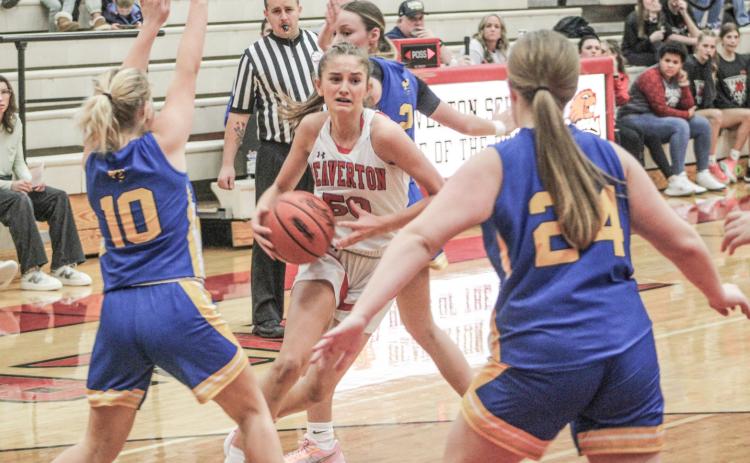 Beaverton’s Myah Hubble drives past one defender and gets ready to try and split two more during Friday night’s 54-24 victory over visiting Harrison.