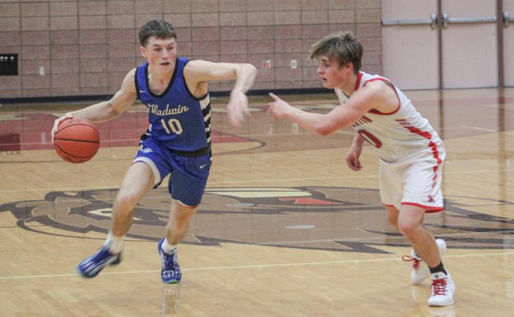 Gladwin’s Seth Mead fends off the defensive pressure applied by Beaverton’s Caiden Loar last Monday night as the Flying G’s won the Battle For Butch.
