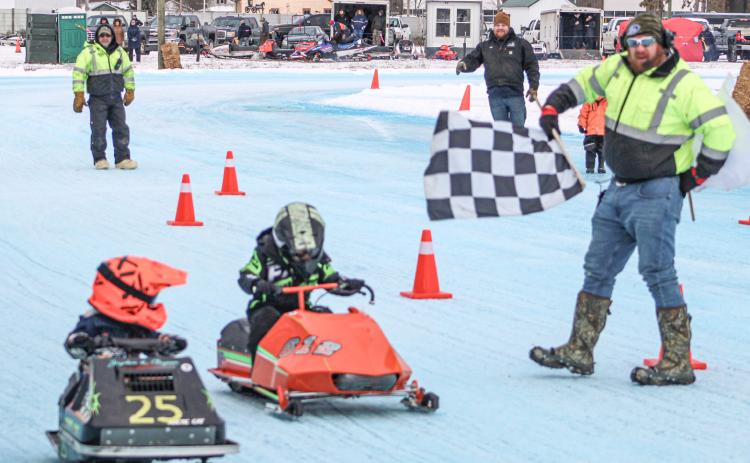 Two drivers in the Kitty Cat Division take the checkered flag at the year’s first Vintage Snowmobile Race at the Gladwin County Fairgrounds.