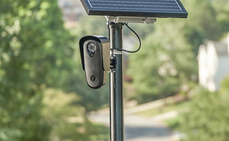 A solar-powered license plate reader mounted on a pole. FLOCK SAFET
