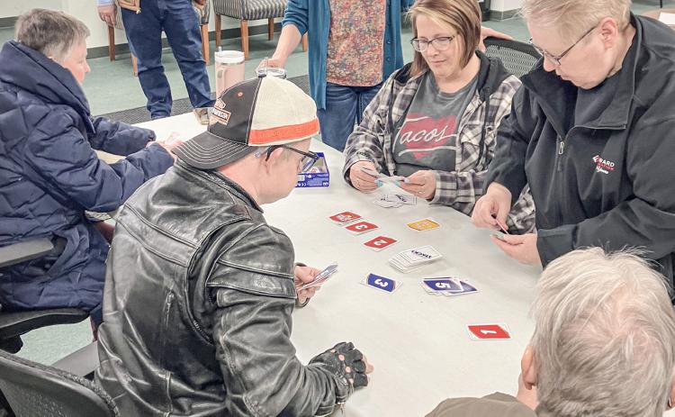 Billings Township Supervisor Tim Mester watches a card game that broke out at the Township Hall last Wednesday as part of Community Activity Day.