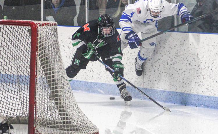 Gladwin’s Ike Wheeler gets up to try and power through a check behind the net Friday night when the Flying G’s and Manistique battled to a 2-2 tie.