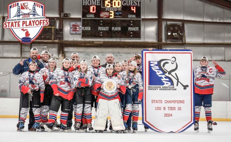 The Gladwin Gladiators hold their MAHA state championship banner on March 3. Pictured are front row, from left: Bronson Dennings, Adalynn Lechner, Payton Card, Maddyson Stalker, Avery Osentoski; second row, from left: Addison Anderson, Noah Scott, Danielle Cornell, Mia Freeman, Donovan Loose; back row, from left: head coach Ryan Harris, Mason Dern, coach Jason Newman, coach Jason Osentoski; holding banner, from left, Korbin Harris, and Preston Newman.