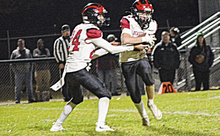 Beaverton quarterback Jace Mishler hands off to Jack Blades during Friday night’s victory at Houghton Lake that clinched a playoff spot for the Beavers.