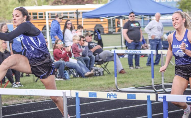 Gladwin’s Ava Gary and Lizzie Haines race to a 1-2 finish in the 100 hurdles during the Legends Track Meet Friday.