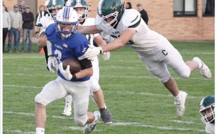 Gladwin’s MJ McDonald runs away from a leaping Clare defender during Friday night’s 14-13 victory that left the Flying G’s alone atop the Jack Pine conference standings with a 3-0 record.