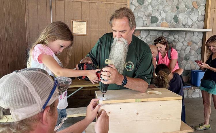 DNR staff help children build wood duck boxes to take home and install in trees near wetlands. These boxes have helped restore wood duck populations throughout Michigan.