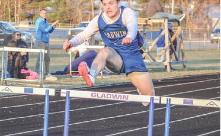 Gladwin’s Colton Pfenninger hurdles his way to a victory during the first outdoor meet of the season last Wednesday.