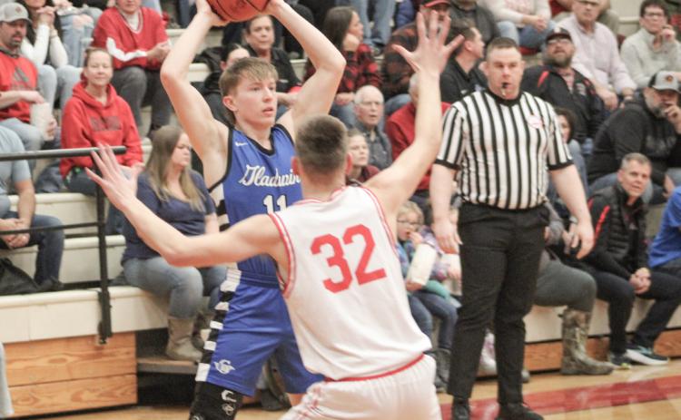 Gladwin’s Brayden Randle holds the ball high and looks for an open teammate while Beaverton’s Jace Mishler applies defensive pressure.