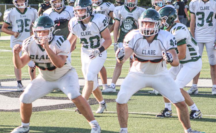 Clare’s offensive linemen get ready for battle before last week’s four-way scrimmage. The Pioneers kick off the season tomorrow night at Grayling.
