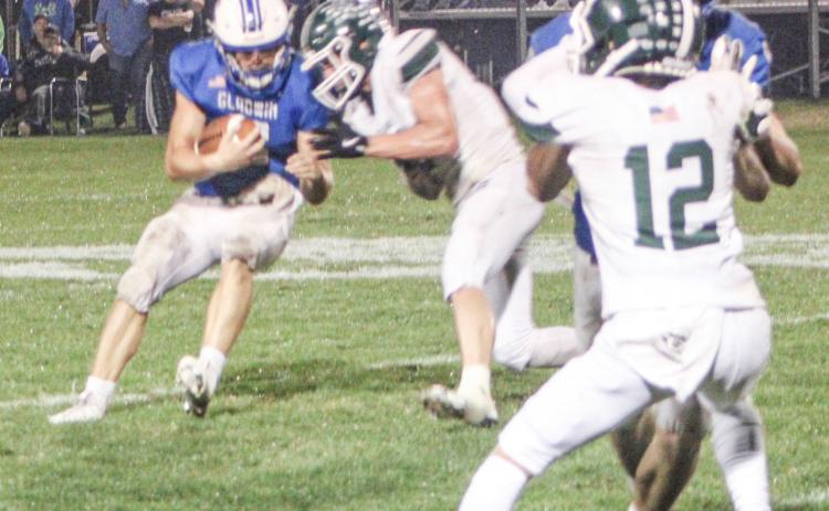 Gladwin quarterback Colton Pfenninger tries to bounce off a hit during Friday night’s dramatic loss to visiting Clare.