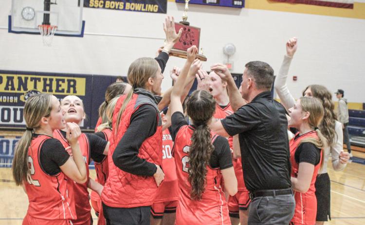 Beaverton’s players and coaches celebrate winning the Jack Pine Conference championship on the court at Standish.