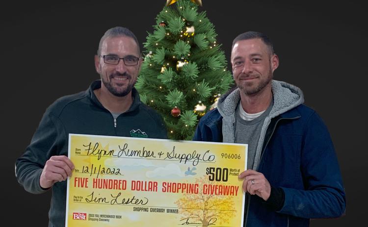 Jerram Dee (left) presents the $500 shopping giveaway check to Tim Lester of Gladwin, one of the two winners.