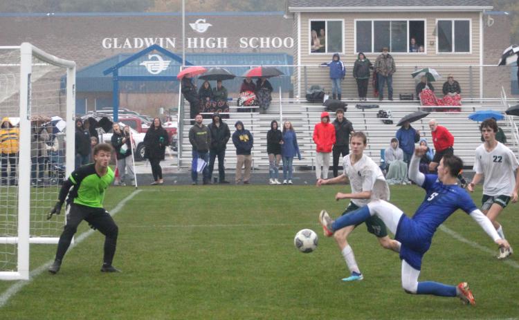 Gladwin’s Connor Ritchie stretches to the limit to try and make a play in front of Freeland’s goal during the district championship game.