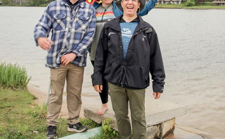Tristan Hewitt and Marah Ranke of the Gladwin County Conservation District celebrate with winner Jim Looker at the end of the River Race of Two Cities at Ross Lake Park.