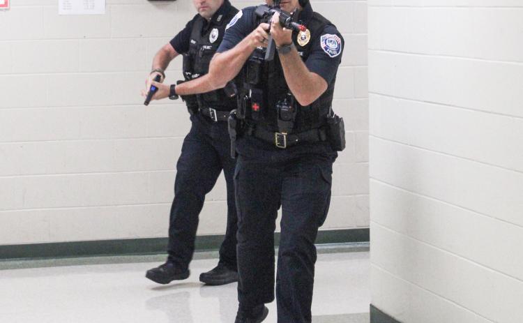 Police officers practice dealing with an active assailant situation during a training session at Gladwin Junior High School Thursday that involved multiple local agencies.