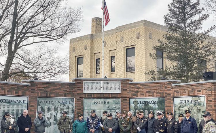 Veterans during the American Legion’s Veterans Day program standing in front of their respective memorials.
