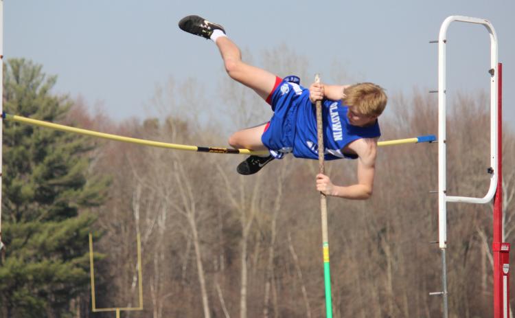 High in the air, Gladwin looks to vault over the pole without knocking it over. Inset photo, Gladwin closely follows Houghton Lake as they compete in hurdle competition.