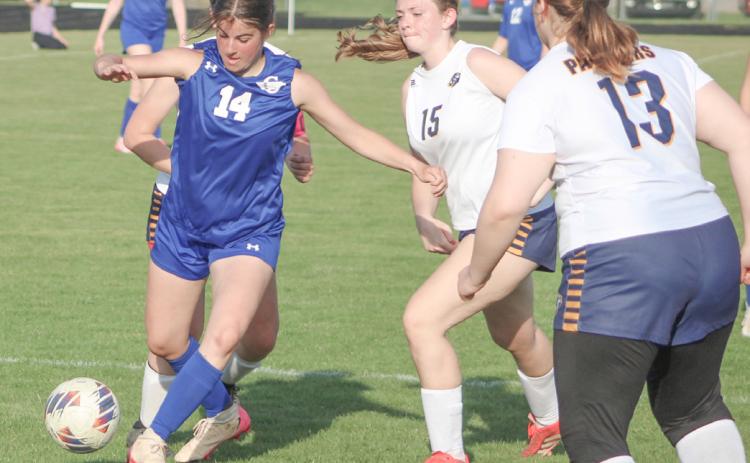 Gladwin’s Macy Spitnale battles three Standish defenders for control of the ball during Thursday’s loss to the visiting Panthers. GLADWIN