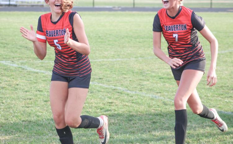 Piper Carland and Braylin Orton run off the field joyously after the Beaverton soccer team beat rival Gladwin 4-1 last week.