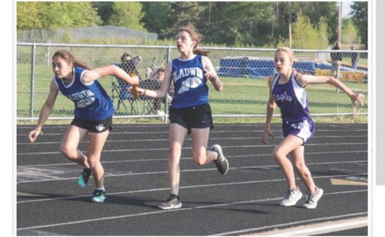 Ruby Vannest hands off to Elizabeth Huisjen during the Conference Championship’s relay race. PHOTO PROVIDED BY ANN MANNING