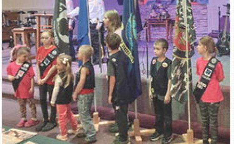 Members of the Road Rangers and the Girls’ Ministry youth groups at Gladwin Assembly of God stand with the flags of the different branches of the service at Sunday’s salute to Vietnam veterans.