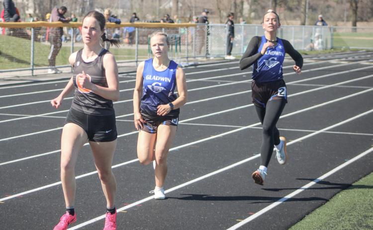 Gladwin’s Jewelia Anderson (left) and Callie Mead push each other toward the finish line during a recent race.