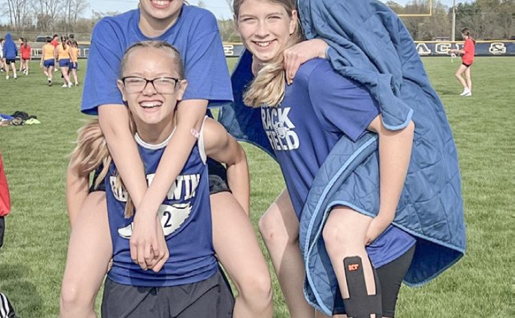 Lily Leinenger and Aria Rule get lifts from Ava Kiger and Avery Graybill after competing in the 400 relay at a junior high track meet last week.